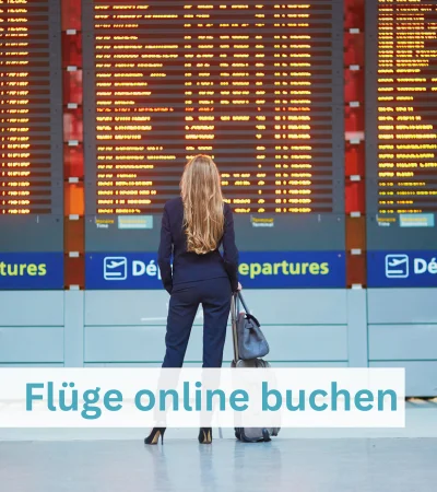 Junge Frau steht in einer Flughafenhalle und blickt auf eine große digitale Abflugtafel mit Flugverbindungen.